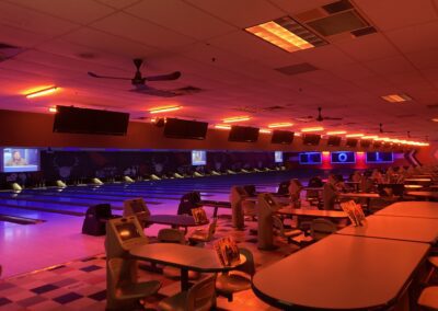 A bowling alley with lights and tables.